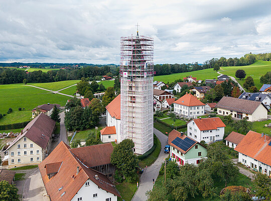 Vollständig eingewickelter Kirchturm mit Fassadengerüst von Kaufmann Gerüstbau für Sanierungsarbeiten in Merazhofen