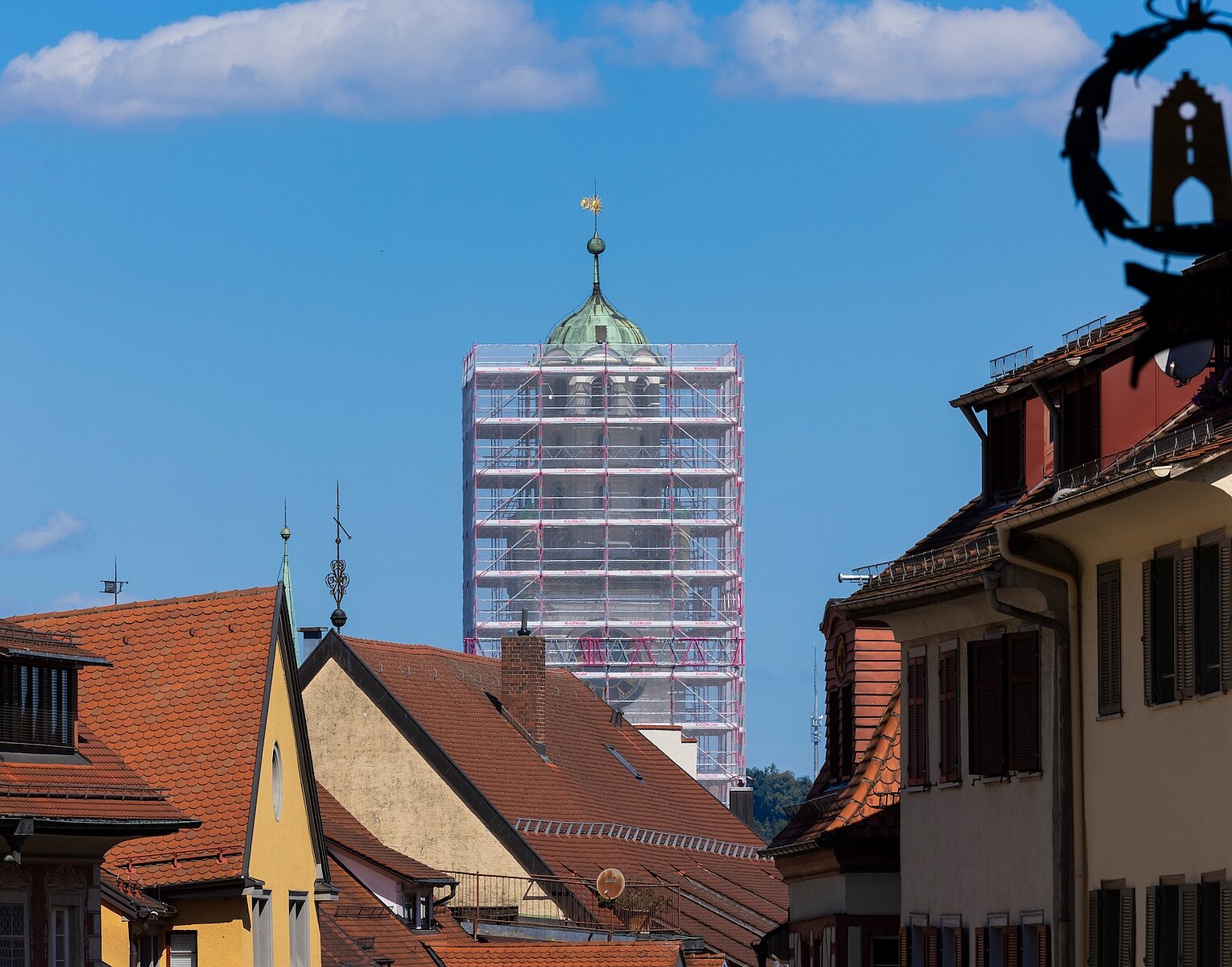 Historische Innenstadt mit Fachwerkhäusern und einem Kirchturm, der von einem Gerüst umgeben ist.